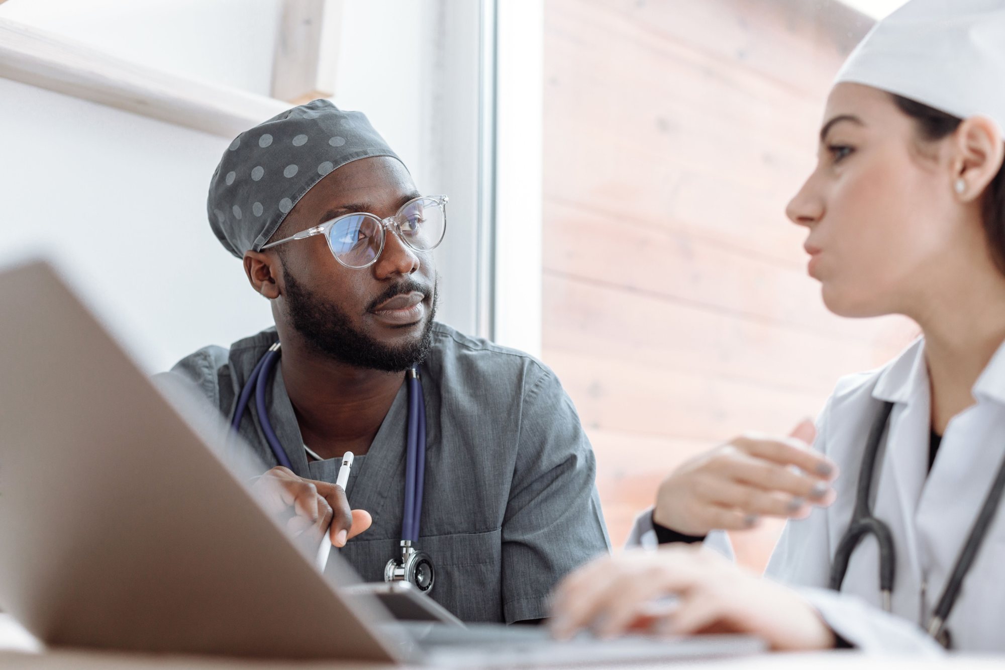 Two clinicians reviewing information at a laptop