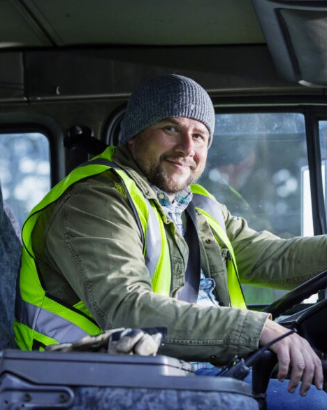 Smiling truck driver seated in the cab of a commercial truck