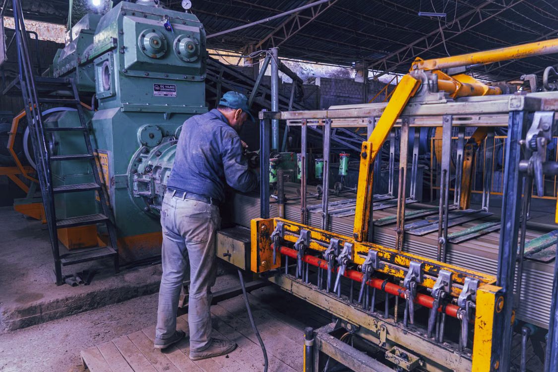 A worker operating industrial machinery on a production line