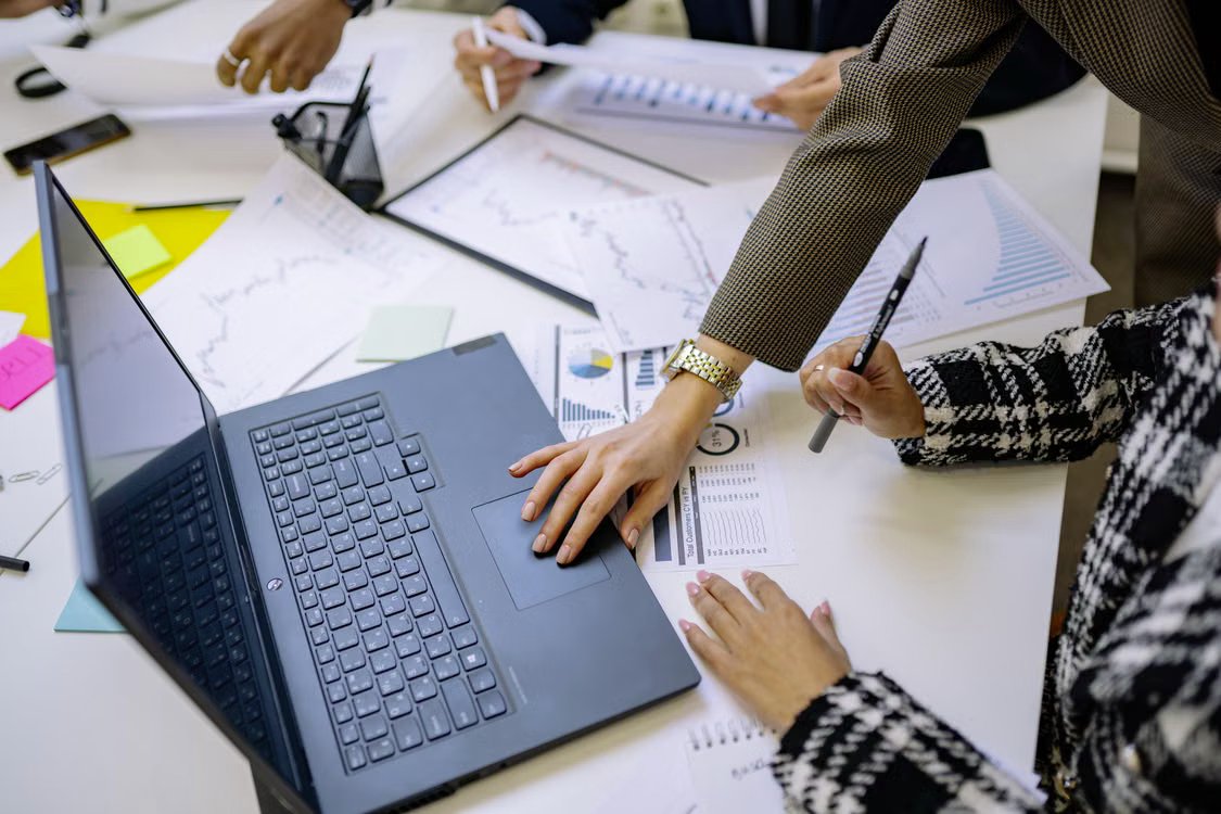 A team reviewing financial reports and charts around a conference table